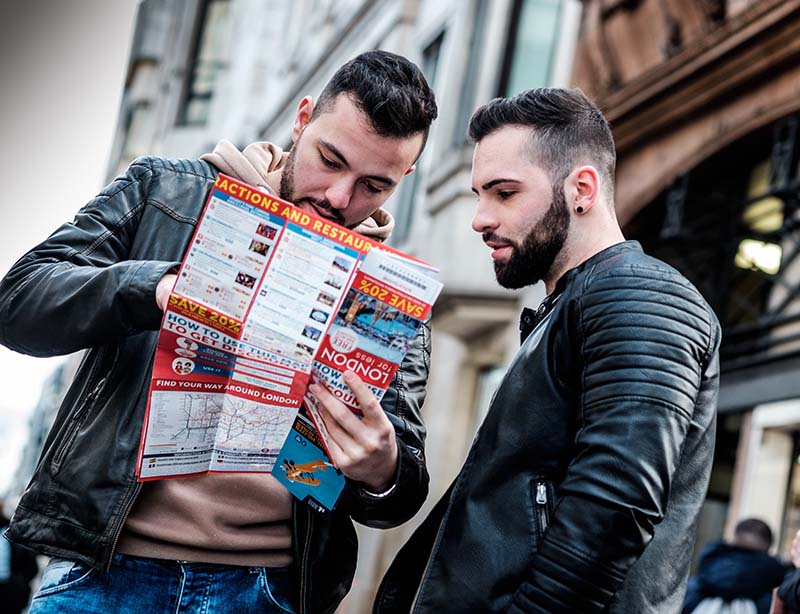 two men reading travel brochure